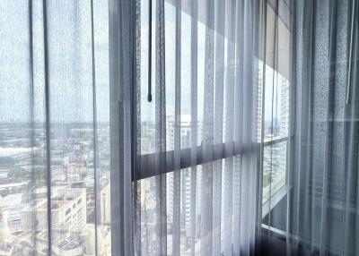 High-rise balcony with city view and sheer curtains