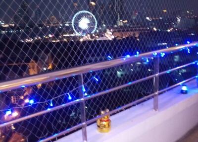 Scenic night view from balcony with cityscape and Ferris wheel