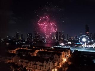 Night view of the city skyline with fireworks and a ferris wheel