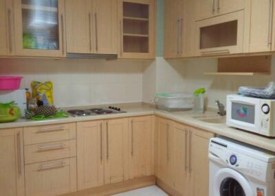 Modern kitchen with light wooden cabinets and appliances