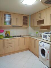 Modern kitchen with light wooden cabinets and appliances