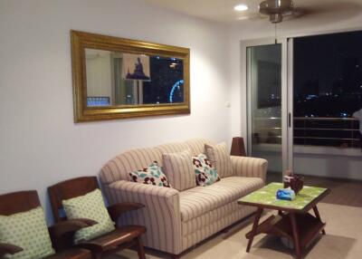 Living room with sofa and chairs, night view through glass door