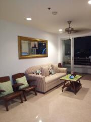 Living room with sofa and chairs, night view through glass door