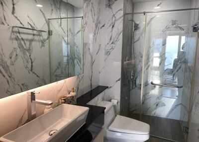 Modern bathroom with marble tiling and glass shower enclosure