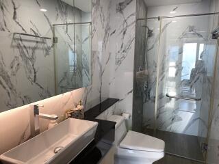 Modern bathroom with marble tiling and glass shower enclosure