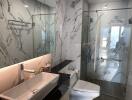 Modern bathroom with marble tiling and glass shower enclosure