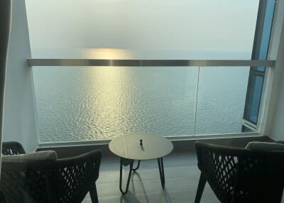 Balcony view of the sea with two chairs and a table