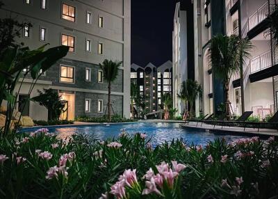 night view of residential buildings with pool and garden