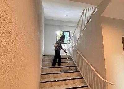 Staircase area with a person cleaning