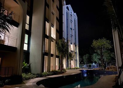 Outdoor view of an apartment building with a pool at night