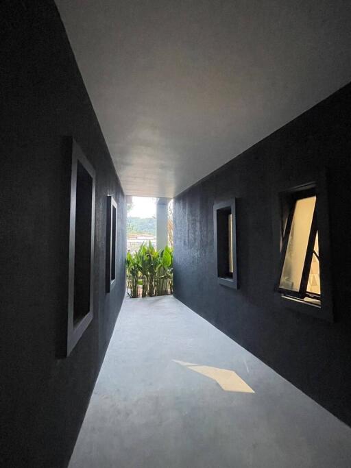 A well-lit hallway with modern design and outdoor greenery