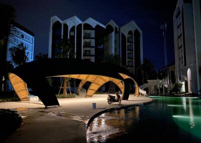 Night view of modern residential complex with illuminated walkways and pool