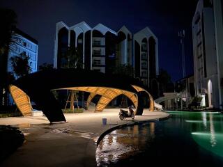 Night view of modern residential complex with illuminated walkways and pool