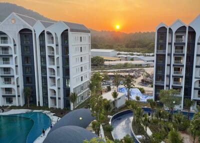 View of modern residential buildings and landscaped pool area at sunset