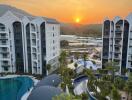 View of modern residential buildings and landscaped pool area at sunset