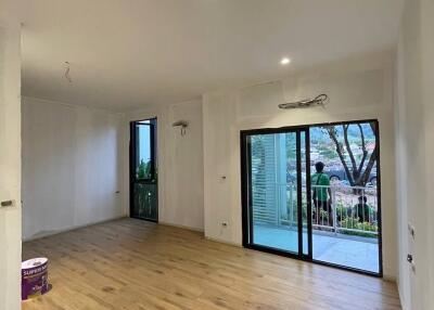 Spacious and well-lit living room with large windows and wooden flooring