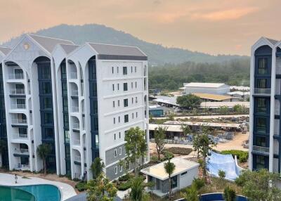 Exterior view of residential buildings with a pool and surrounding landscape