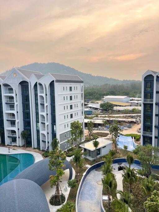 Exterior view of residential buildings with a pool and surrounding landscape