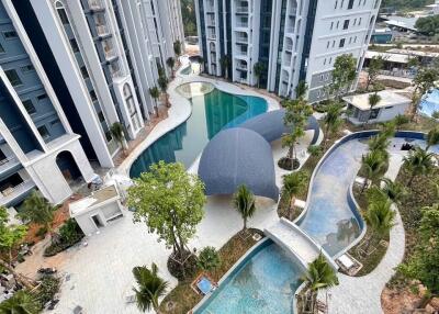 Aerial view of modern apartment complex with swimming pools and landscaped gardens