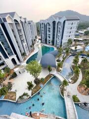 Aerial view of modern apartment complex with swimming pools and landscaped gardens