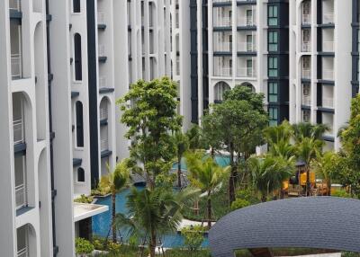 Modern apartment buildings with swimming pools and lush greenery