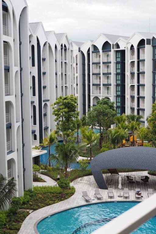 Modern apartment buildings with swimming pools and lush greenery