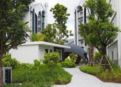 Modern residential buildings with lush greenery and pathway