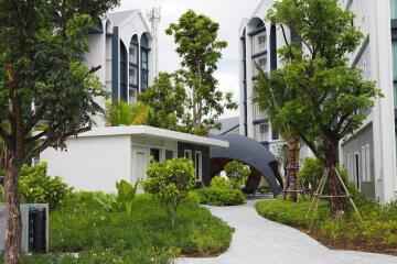 Modern residential buildings with lush greenery and pathway