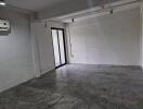 Vacant room with concrete floor and glass door