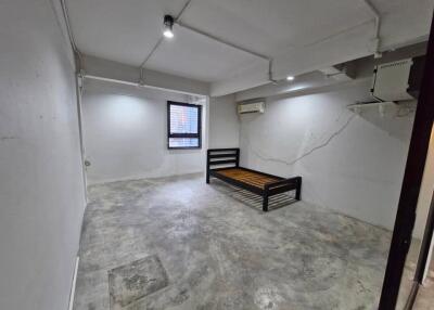 Empty bedroom with concrete floor and single bed frame