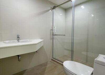 Modern bathroom with glass shower, sink, and toilet