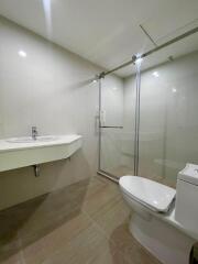 Modern bathroom with glass shower, sink, and toilet