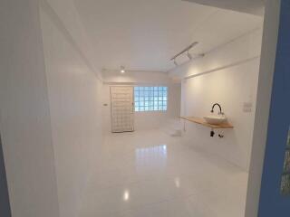 Minimalist white kitchen with sink and counter