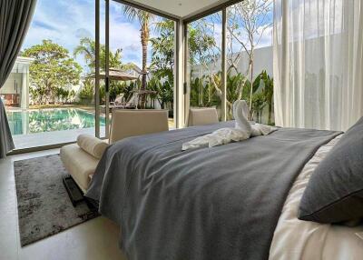 Modern bedroom with large windows overlooking a pool