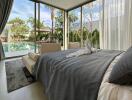 Modern bedroom with large windows overlooking a pool