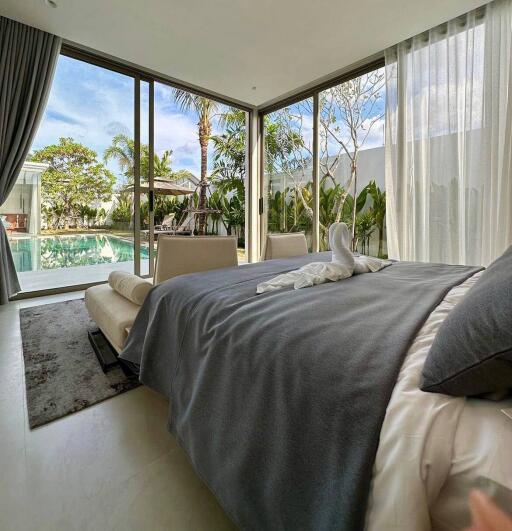 Modern bedroom with large windows overlooking a pool