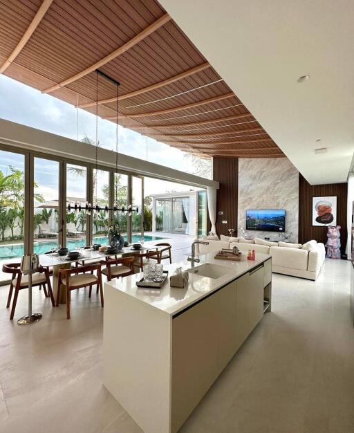 Spacious living area with open kitchen and pool view