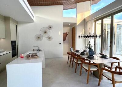 Modern dining area with high ceiling and natural light