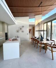 Modern dining area with high ceiling and natural light