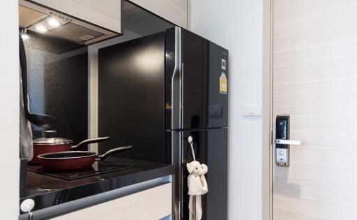 Modern kitchen with black refrigerator and cooking area