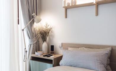 Cozy modern bedroom with bedside table, lamp, and decorative items