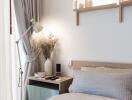 Cozy modern bedroom with bedside table, lamp, and decorative items