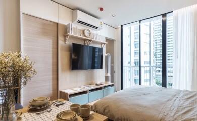 Modern bedroom with large windows, TV, air conditioner, and dining table