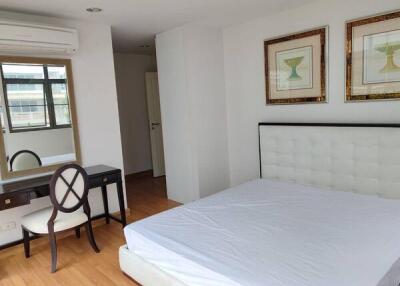 Bedroom with bed, dressing table, chair, and wall decorations