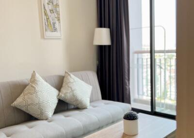 Modern living room with a sofa, coffee table, and balcony access