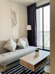 Modern living room with a sofa, coffee table, and balcony access