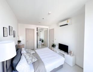 Modern bedroom with air conditioning, bed, TV, and minimalist decor