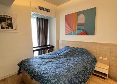 Bedroom with double bed, wooden floor, and a painting