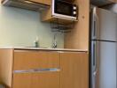 Modern kitchenette with fridge and microwave