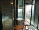 Modern balcony with table and chairs, overlooking cityscape